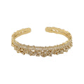 KEVOUR 18K gold-filled open cuff bracelet featuring scattered baguette and round-cut cubic zirconia crystals.