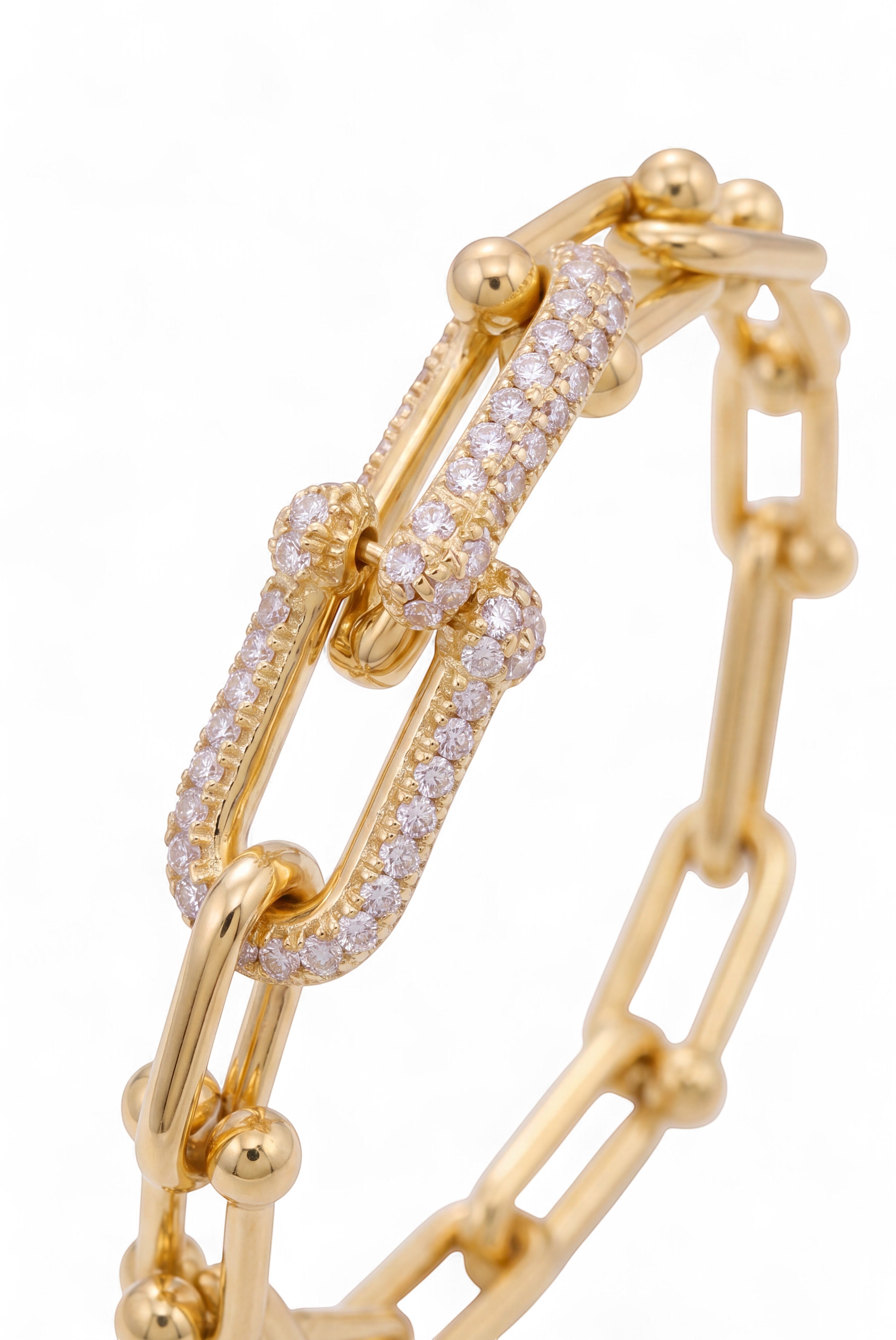 KEVOUR gold-tone link chain bracelet featuring a central clasp embellished with shimmering pavé crystals